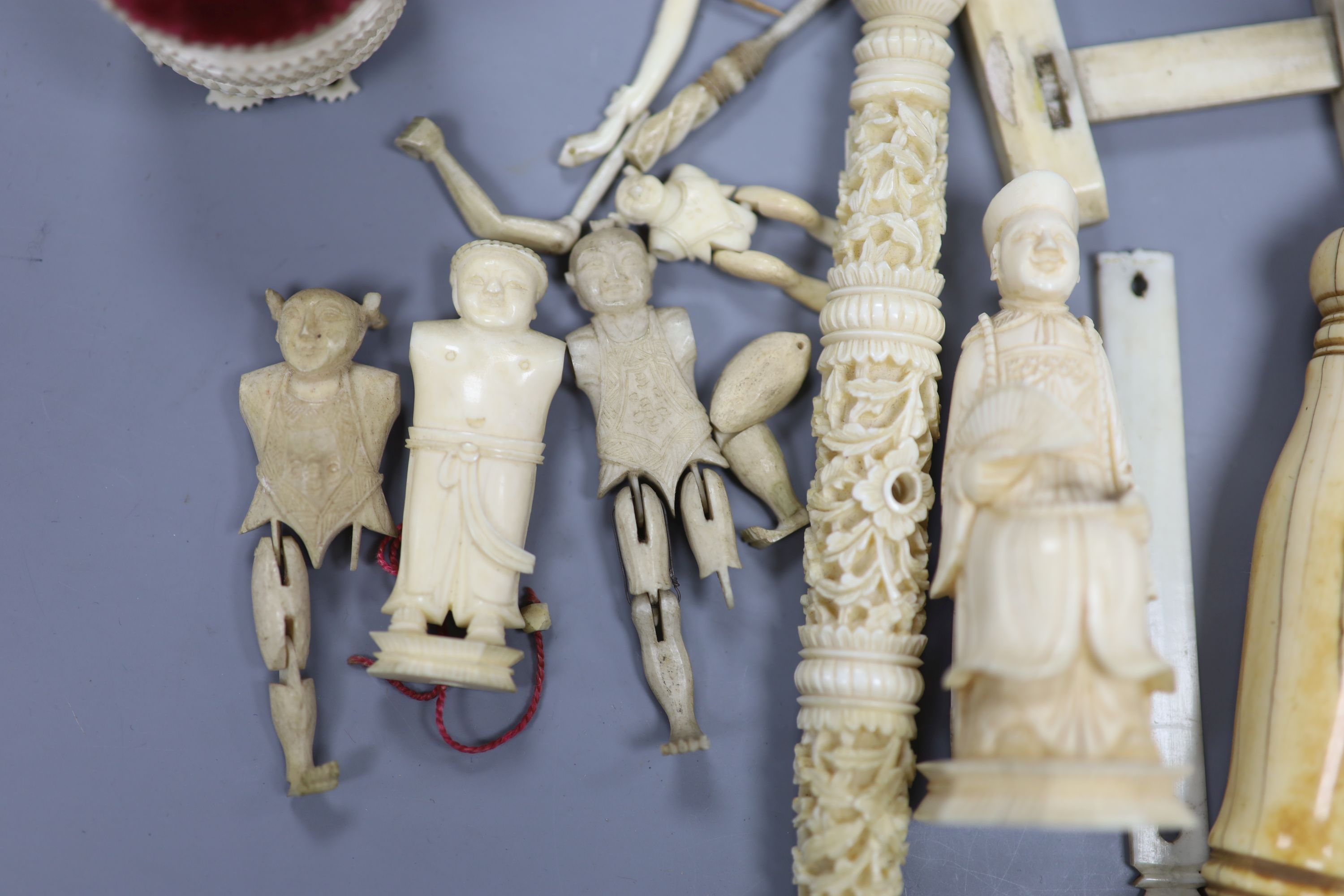 Three Chinese articulated ivory models of acrobats, two chess pieces, an ivory brush handle and needlework items